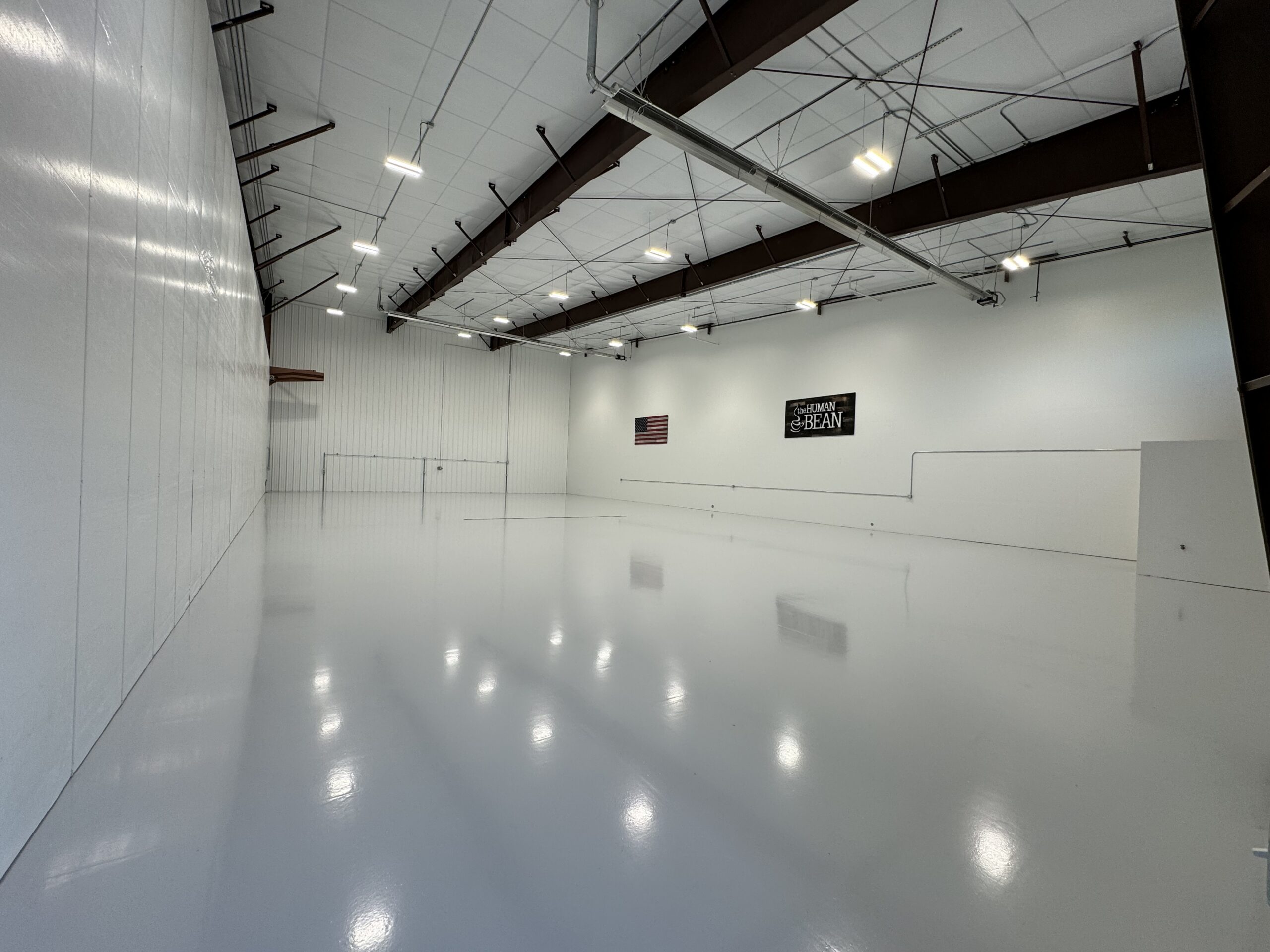 Completed high-gloss commercial floor coating in a large Southern Oregon facility