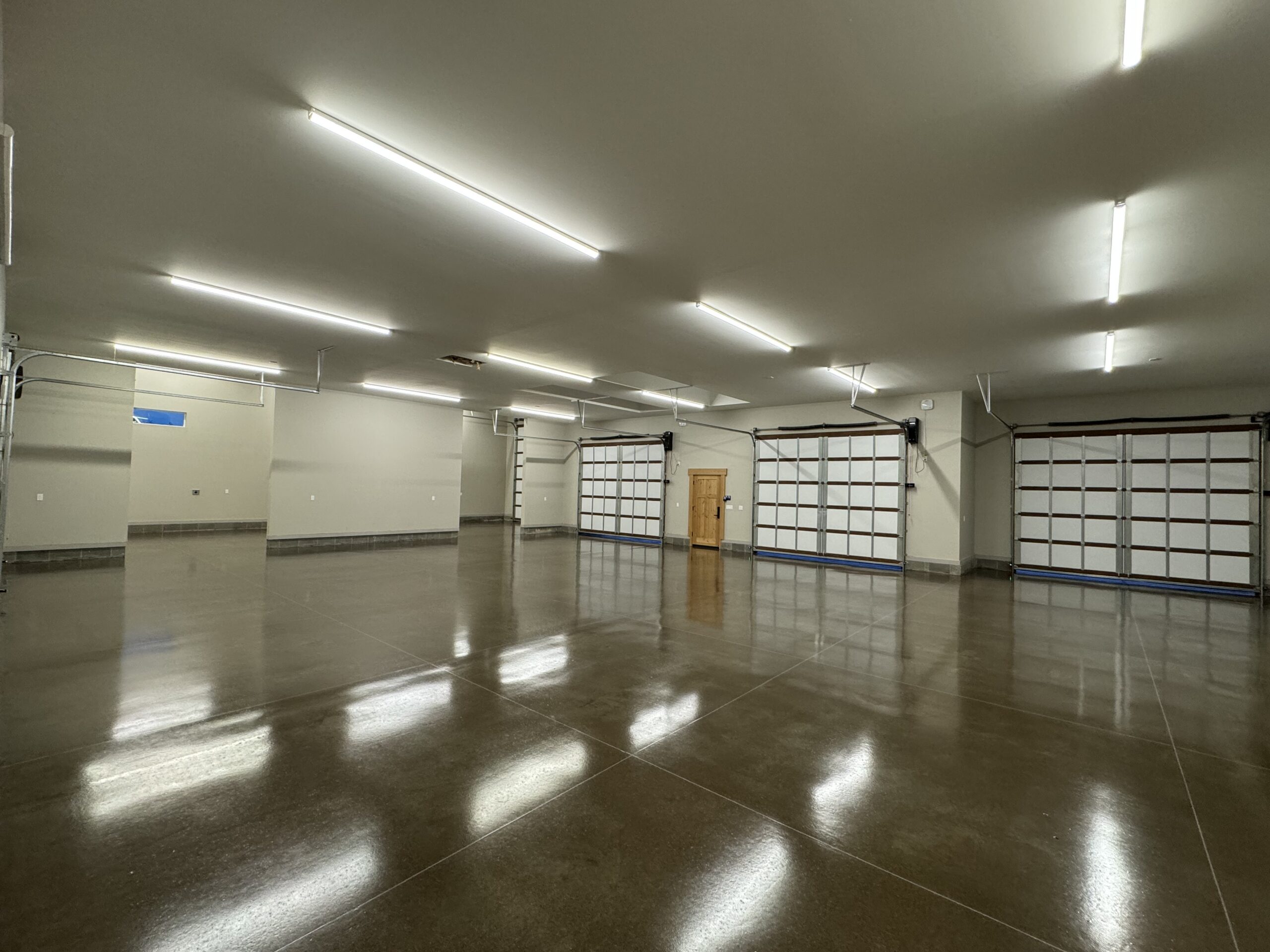 Finished reflective concrete floor coating inside a multi-bay garage